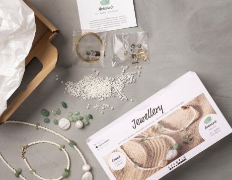 Smykke DIY kits åbnet op og indhold vist på et bord
