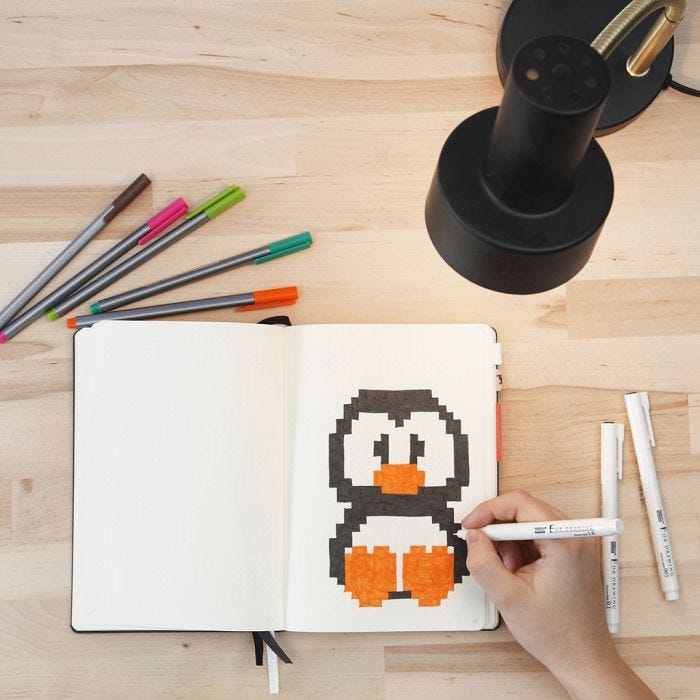 Pixel art pingvin tegnet i bullet journal