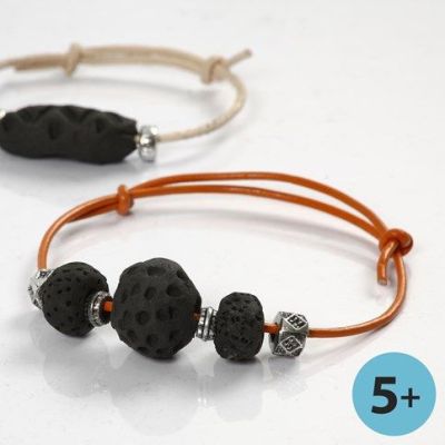 Armb&aring;nd af lerperler, sortbr&aelig;ndte p&aring; b&aring;l