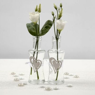 Vase dekoreret med hvidt satinbånd og hjerte