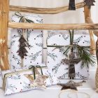Julegaveindpakning med grangren-motiv pyntet med snor, bånd og gavemærke i naturbark