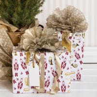 Julegaveindpakning med nøddeknækker motiv og pompon af silkepapir