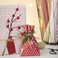 Julegaveindpakning med gren og kunstige bær