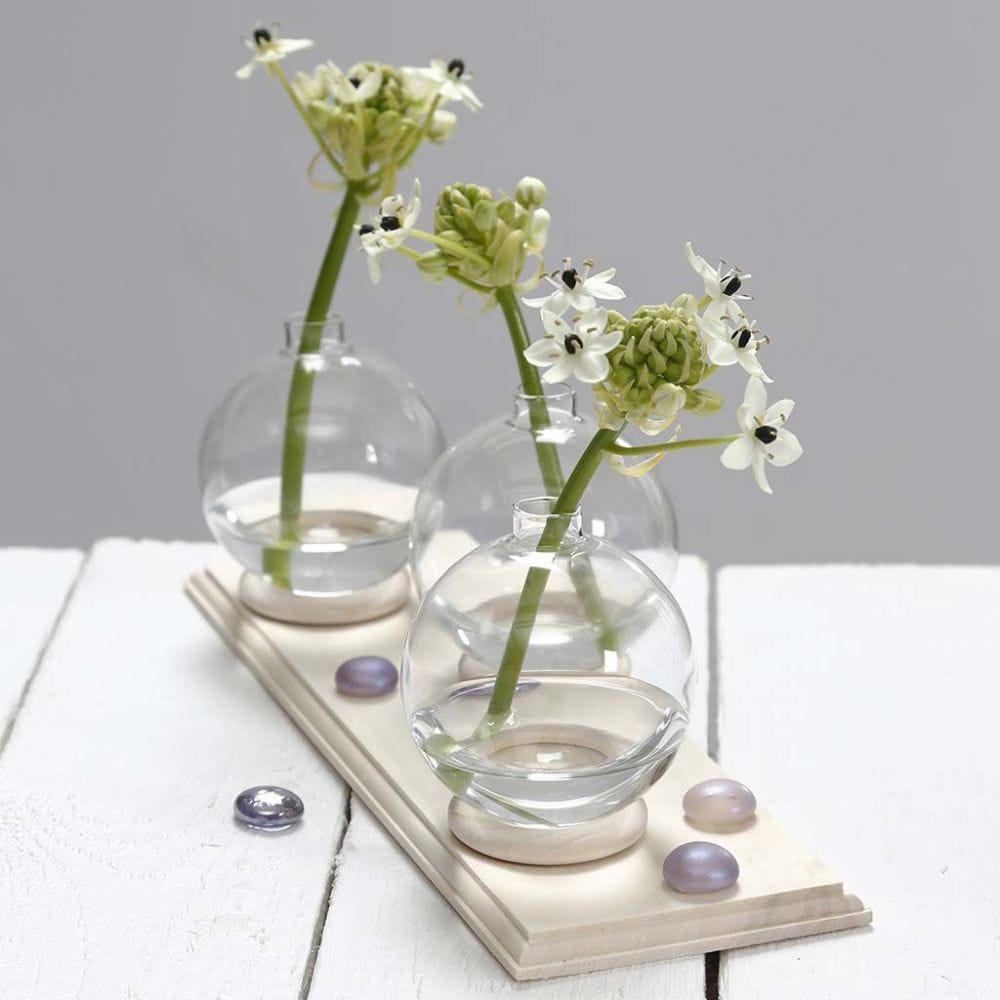 Lille vase af glaskugle stående på gardinring