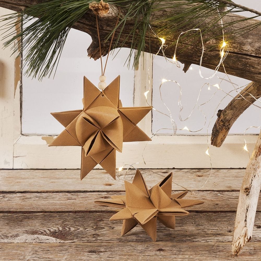 Flettet julestjerne af læderpapir stjernestrimler ophængt med lædersnor og træperler